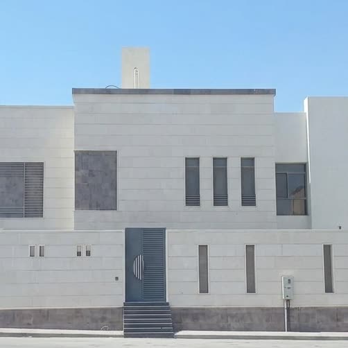 فيلا حديثة بيضاء بنوافذ طولية بسيطة
